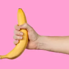 Dłoń trzymająca banana, sugerująca pozycje do masturbacji.