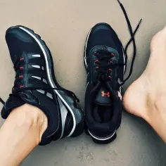 Stópkarz w czarnych butach sportowych z czerwonymi akcentami, gotowy do biegu.