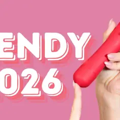 Trendy 2026: odkryj najlepsze gadżety erotyczne. Czerwony wibrator w dłoni na różowym tle.