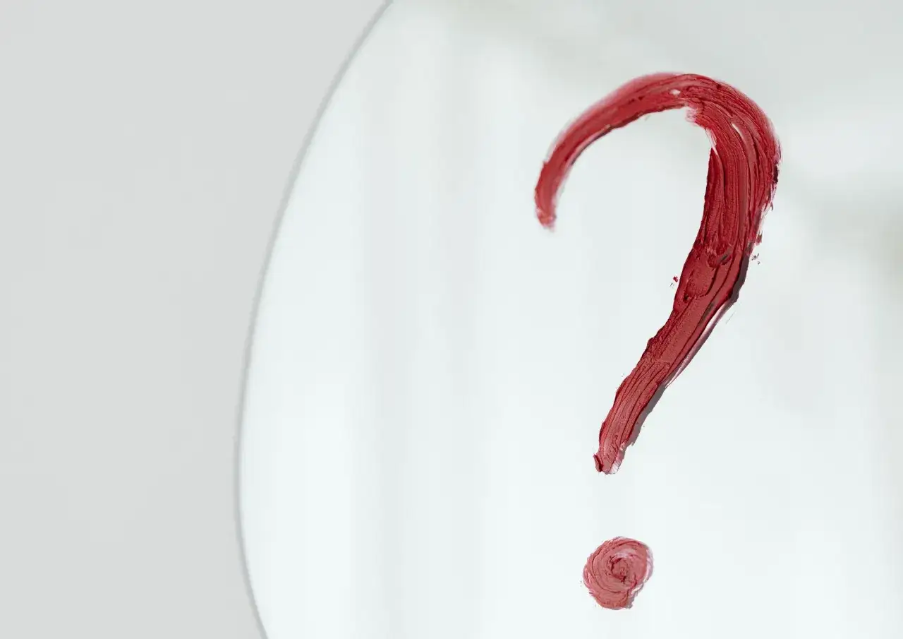 Czerwony znak zapytania namalowany szminką na lustrze. Czy to symbol pytania o dysforię płciową, co to jest?